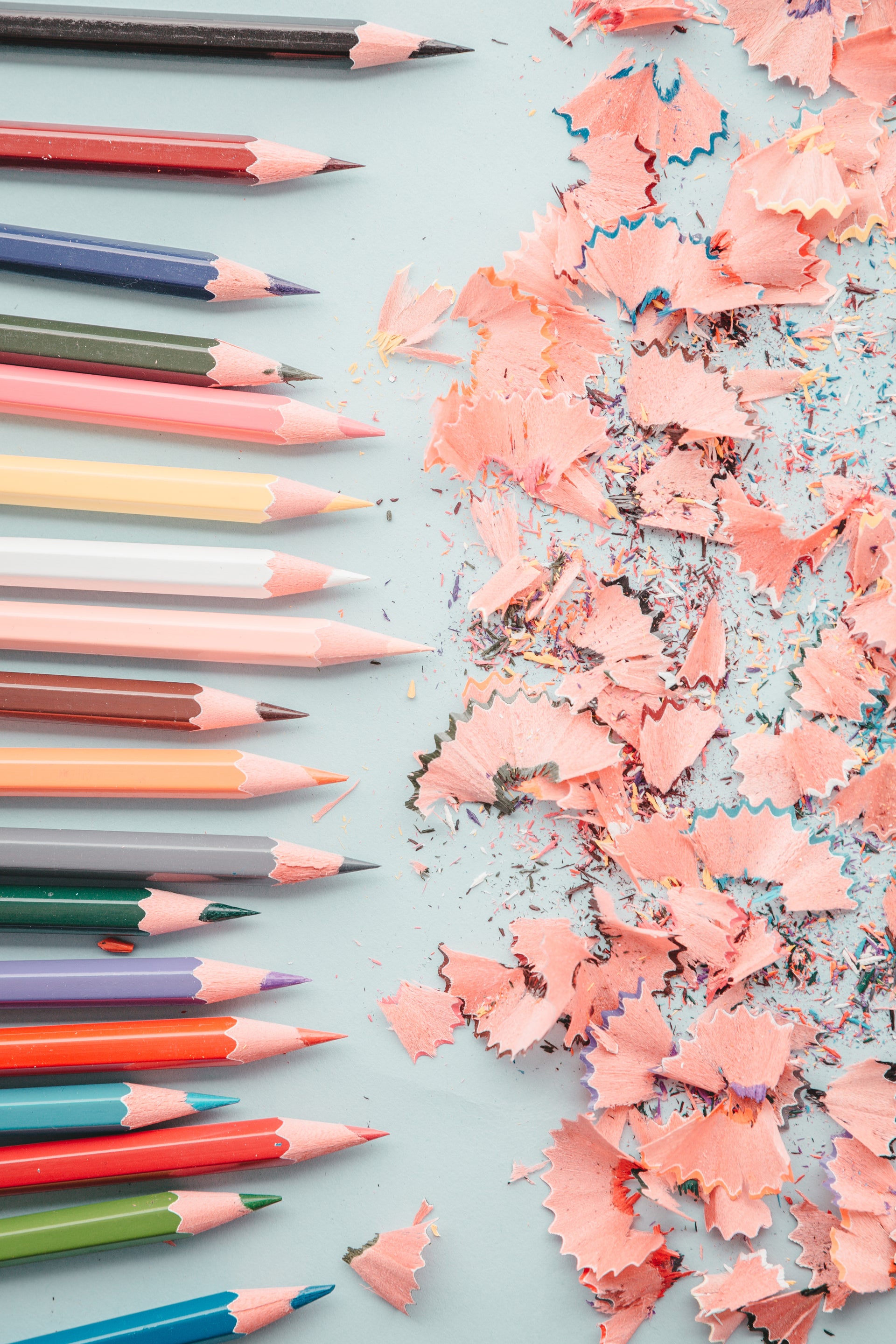 coloured pencils and pencil sharpenings on pale background